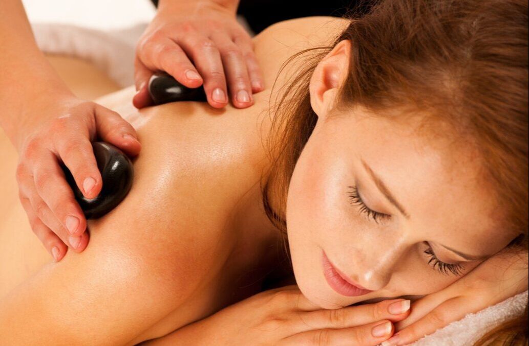 A woman receiving hot stone massage
