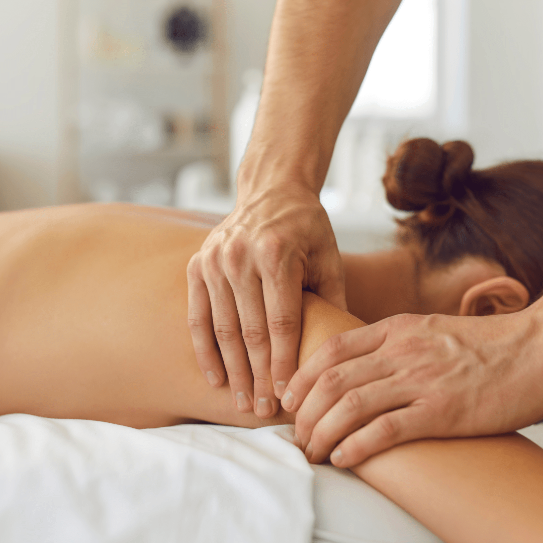 A woman receiving a professional deep tissue massage on her shoulder