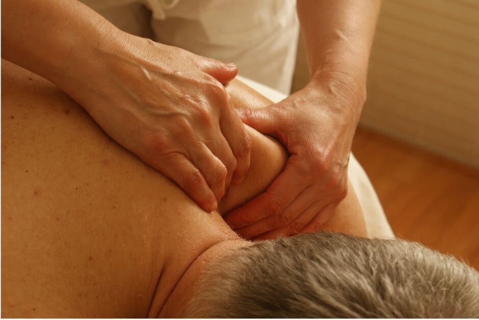 A man receiving a professional massage on his shoulders