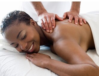 A smiling woman receiving massage therapy