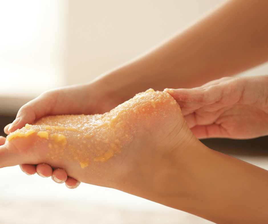 A foot is being massaged with a sugar scrub for exfoliation and relaxation