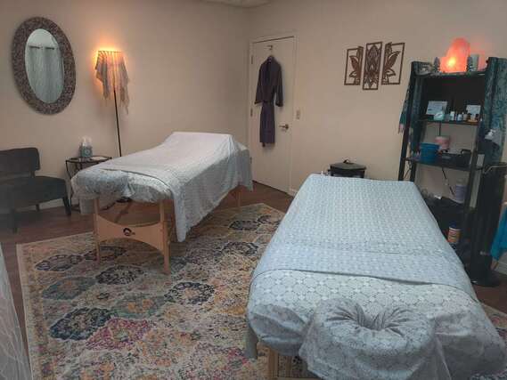 Two massage therapy tables set up side by side in a relaxing room