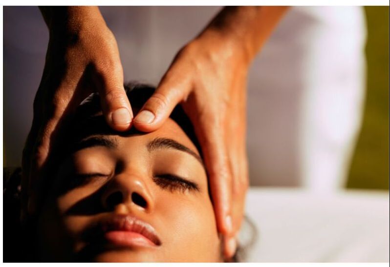 A woman receives a face and head massage