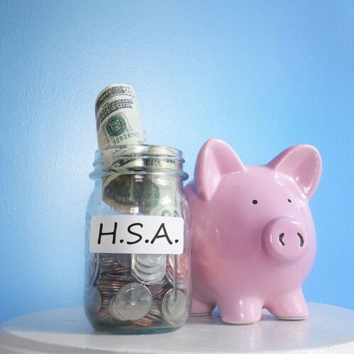 Pink Piggy Bank and Clear Jar with Paper Money in it, with a blue background