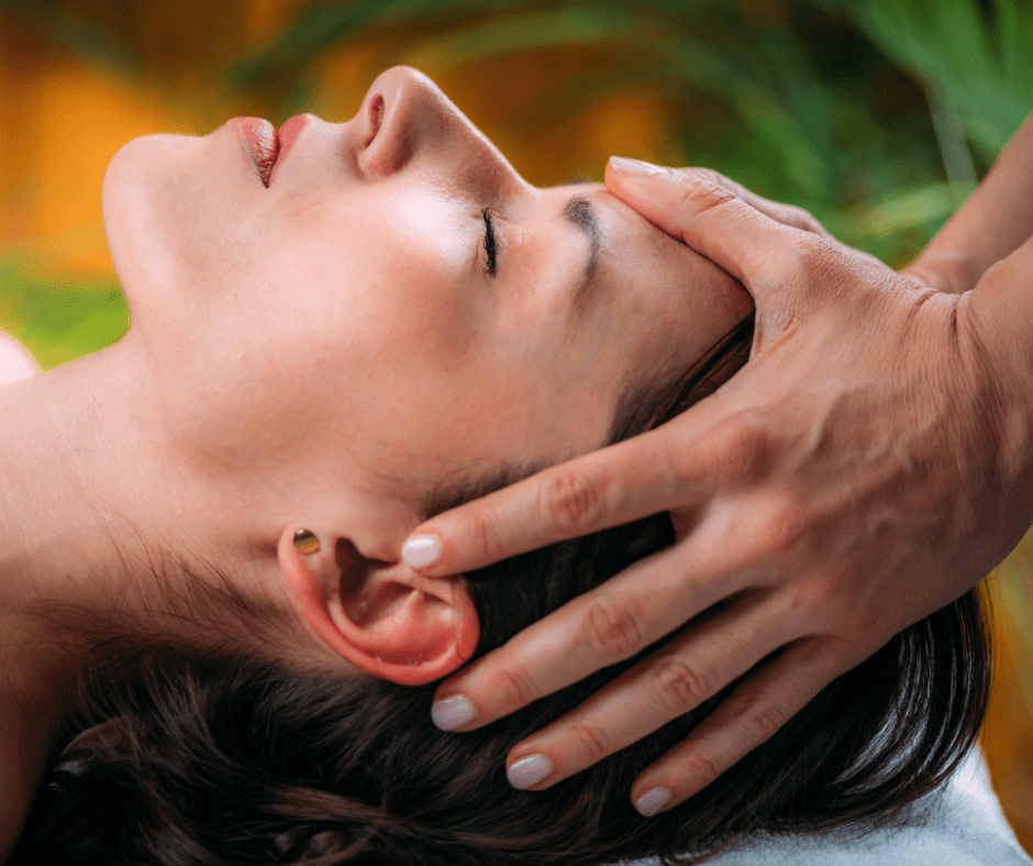 Massage therapist massaging a woman's head.